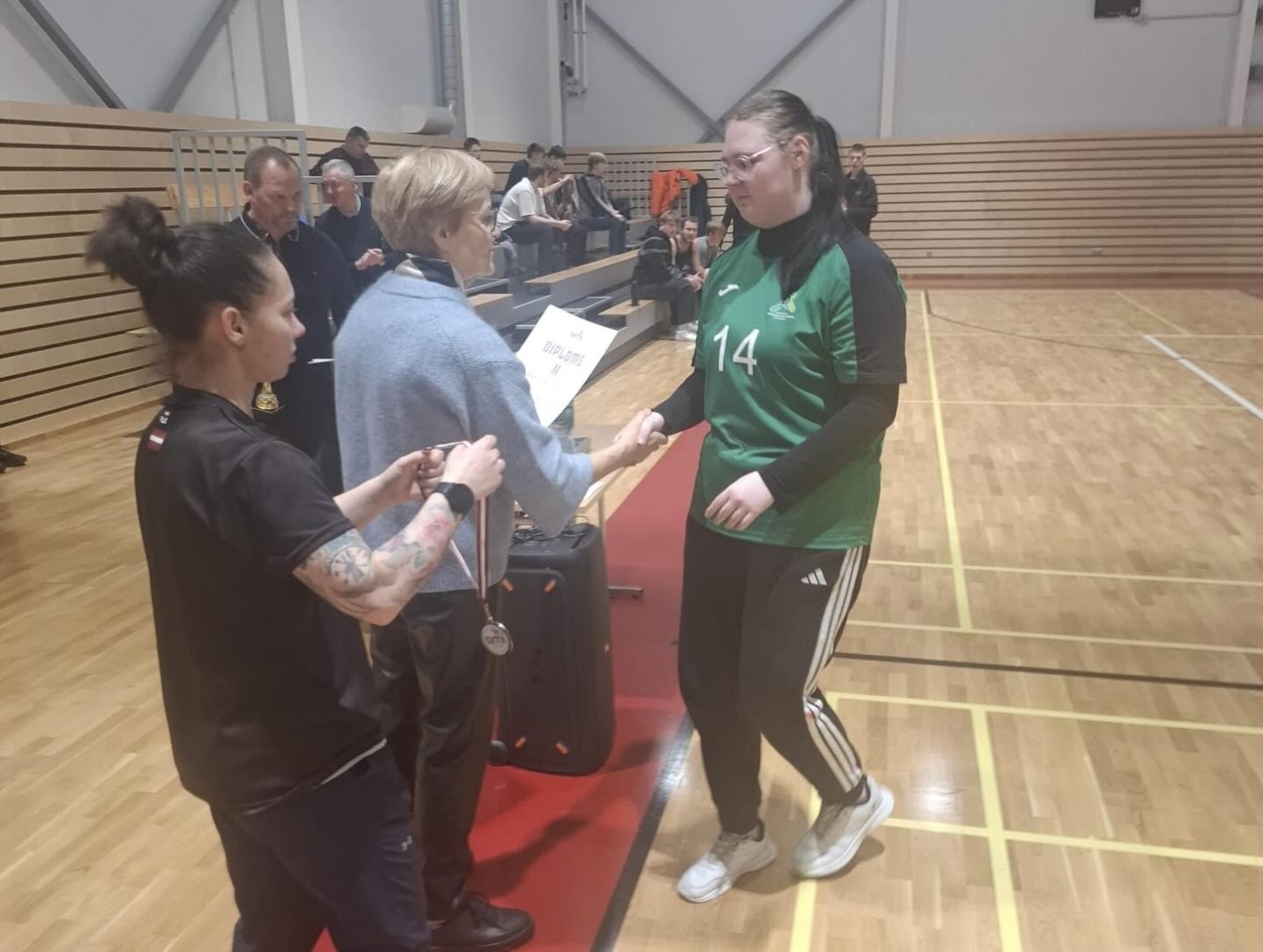 Spēlētājas saņem diplomu un medaļu par augstu sasniegumu basketbola 3×3 finālsacensībās.