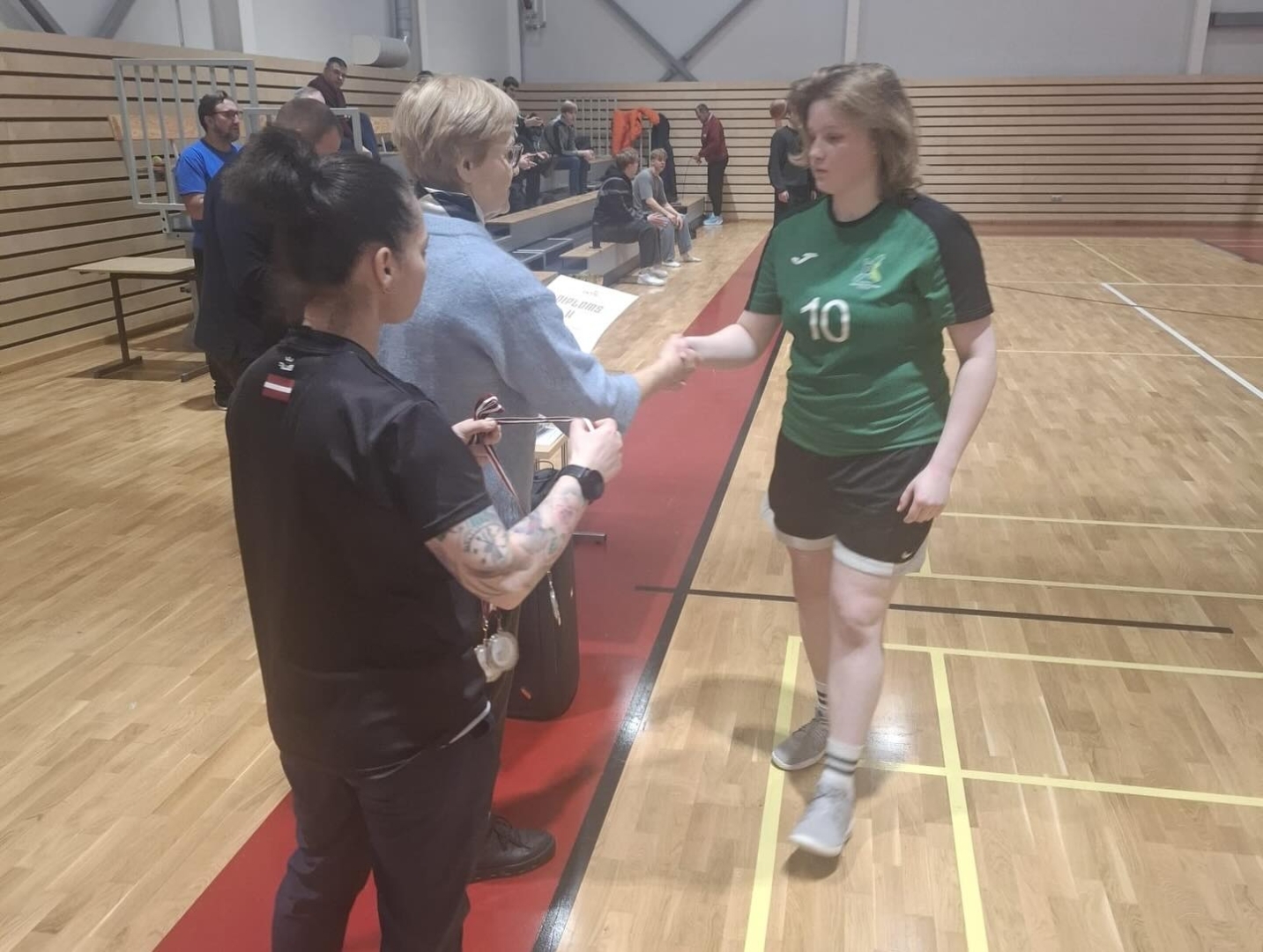 Komandas kapteine saņem kausu par izcīnīto 2. vietu Latvijas basketbola 3×3 finālā.