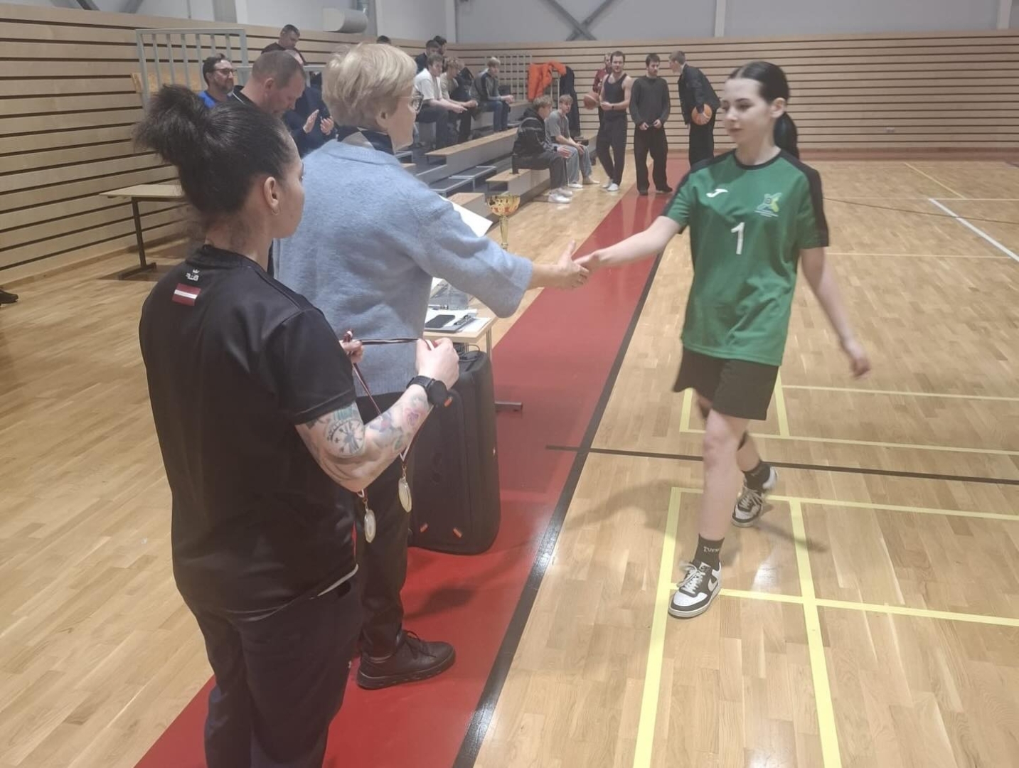 Basketbola 3×3 sacensību apbalvošanas brīdis ar spēlētāju un tiesnešu klātbūtni.