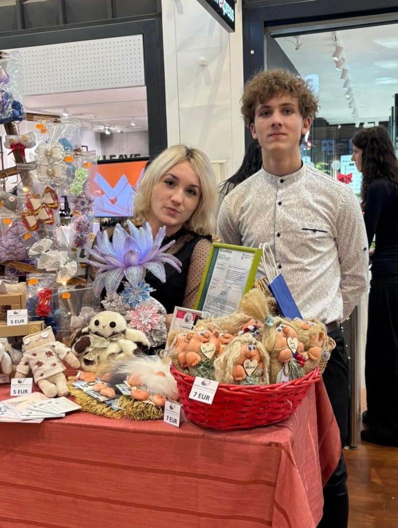 Skolēnu mācību uzņēmuma “Brīnumrotaļa” pārstāvji pie sava stenda pasākumā “Cits Bazārs”, prezentējot ar rokām darinātas rotaļlietas.