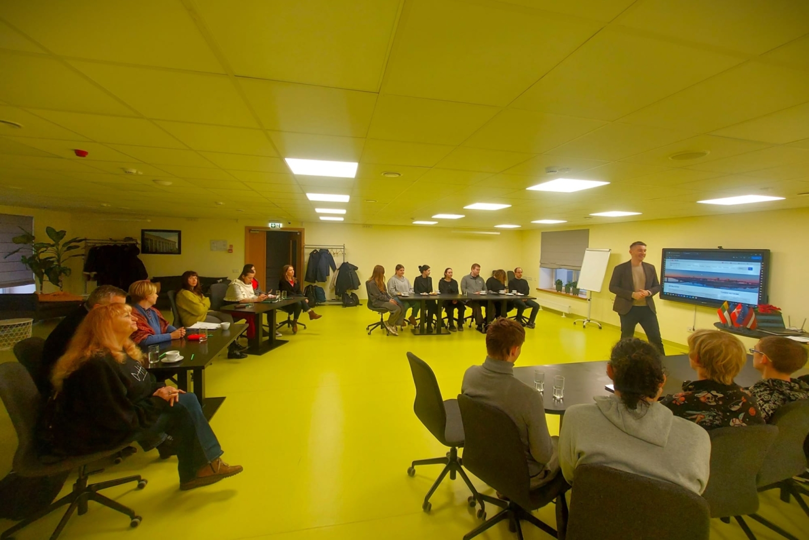 Seminārs par uzņēmējdarbību Daugavpils Tehnoloģiju un tūrisma tehnikumā, dalībnieki klausās lektoru mācību telpā