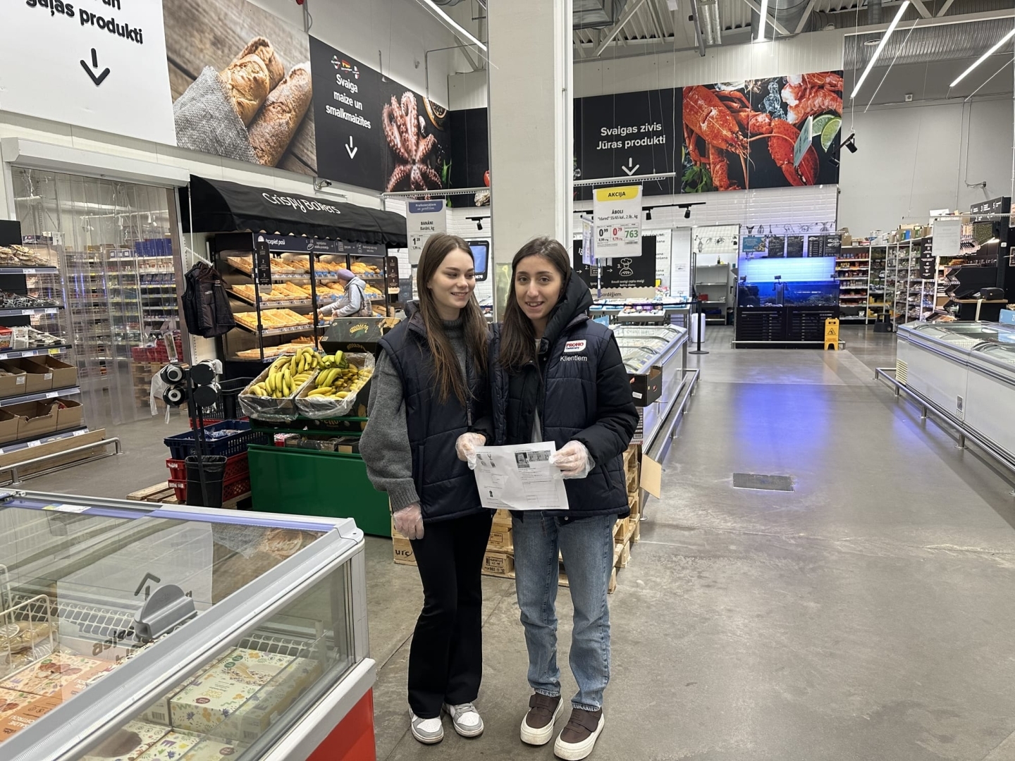 LD-41 grupas izglītojamās ar uzdevumu lapu PROMO Cash&Carry tirdzniecības zālē