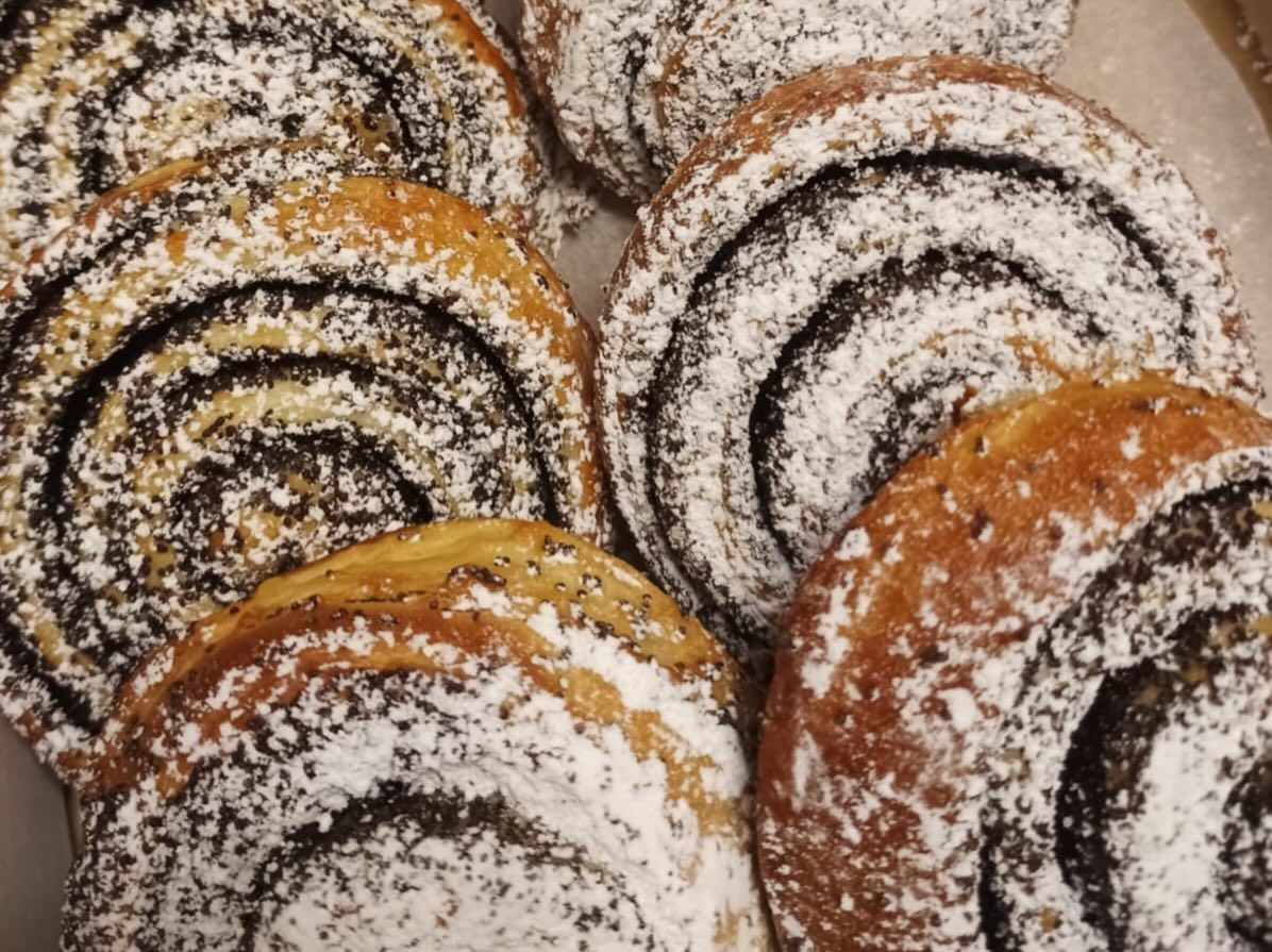 Tuvplāns ar svaigi ceptām magoņu smalkmaizītēm, pārkaisītām ar pūdercukuru, kas pagatavotas neformālās izglītības kursu laikā.