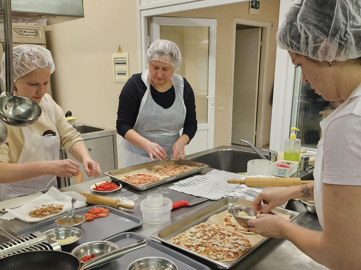 Neformālās izglītības kursa “Pica – garšas eksplozija” dalībnieki praktiskajā nodarbībā gatavo picas, ievērojot bezatkritumu un ilgtspējīgas ēdienu gatavošanas principus.