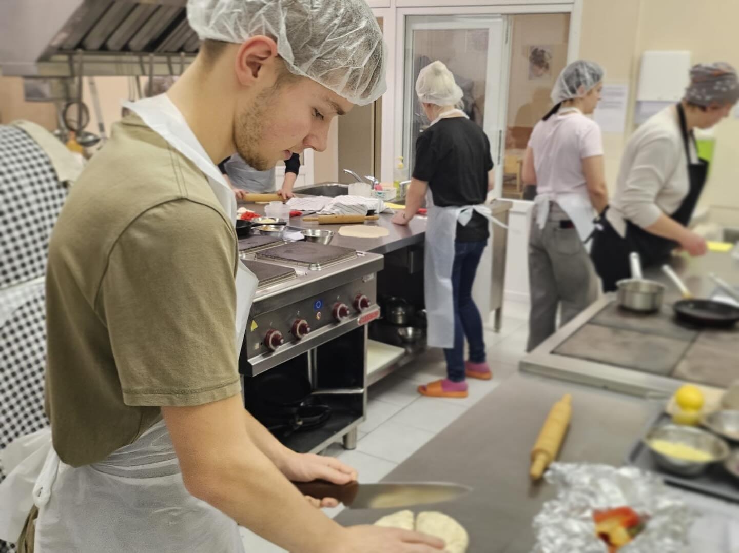 Kursa “Pica – garšas eksplozija” dalībnieks strādā ar picas mīklu profesionālajā mācību virtuvē Miera ielas mācību korpusā.