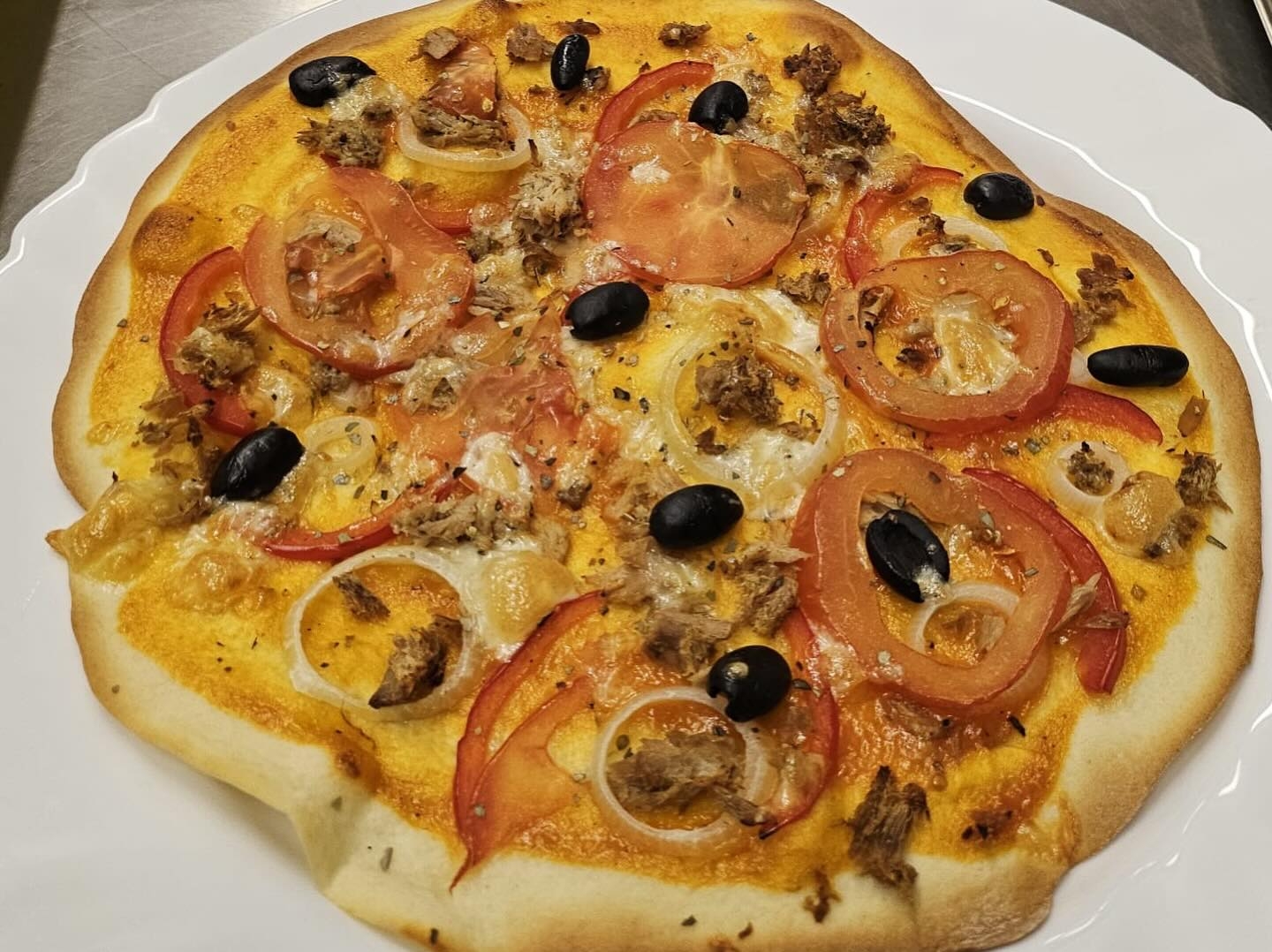 Pašu gatavota pica ar dārzeņiem un citām sastāvdaļām, kas pagatavota neformālās izglītības kursu praktiskajā daļā.