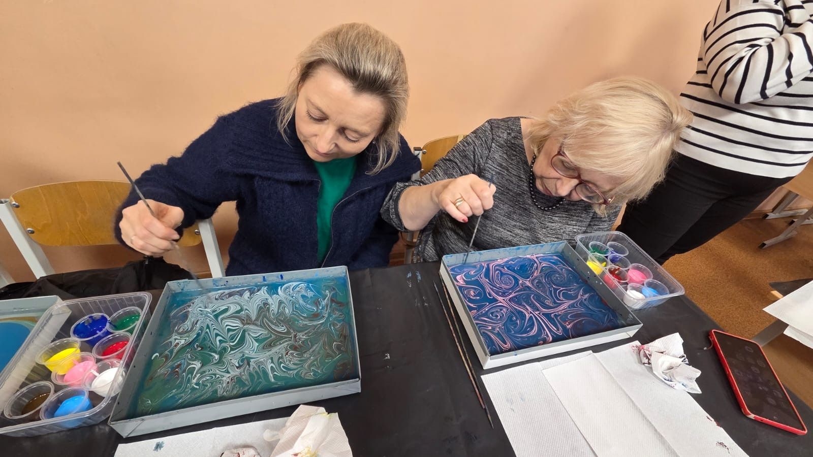 Radošā darbnīca, kur dalībnieki veido mākslas darbus marmorizēšanas tehnikā