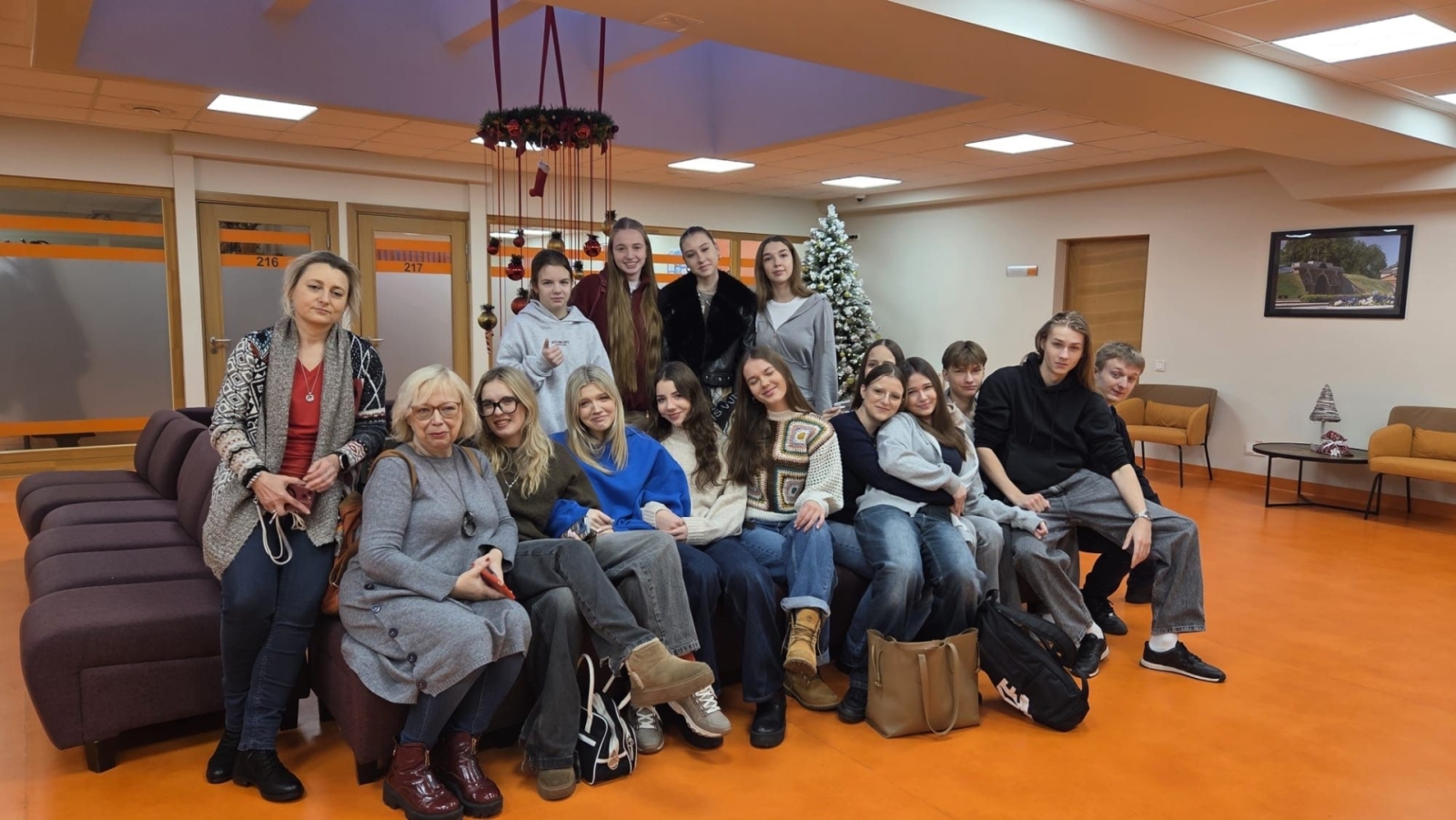 Latvijas un Polijas skolēni un skolotāji kopbildē tehnikuma vestibilā Ziemassvētku noskaņā