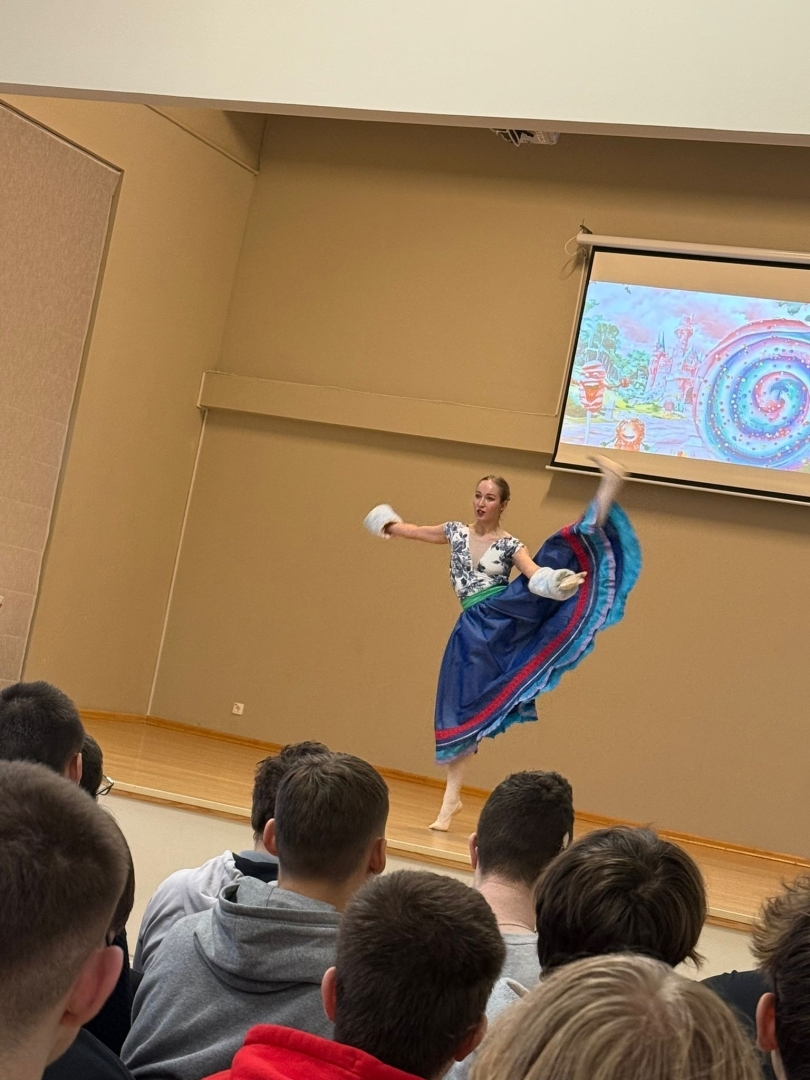 Baleta izrādes “Riekstkodis” aina ar dejotāju tautiskā stila tērpā uz skatuves.