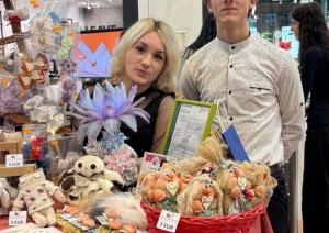 Skolēnu mācību uzņēmuma “Brīnumrotaļa” pārstāvji pie sava stenda pasākumā “Cits Bazārs”, prezentējot ar rokām darinātas rotaļlietas.
