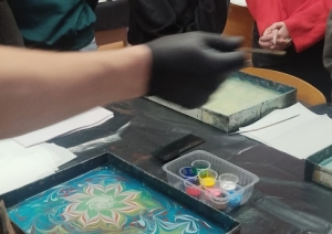 Izglītojamie vēro ebru gleznošanas procesu un gatavojas pārnest zīmējumu uz papīra