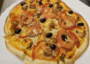 Pašu gatavota pica ar dārzeņiem un citām sastāvdaļām, kas pagatavota neformālās izglītības kursu praktiskajā daļā.