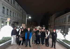 Latvijas un Polijas skolēni vakara pastaigā pilsētā pie svētku gaismas objektiem