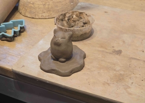 No māla veidota neliela figūriņa uz darba galda keramikas praktiskās nodarbības laikā